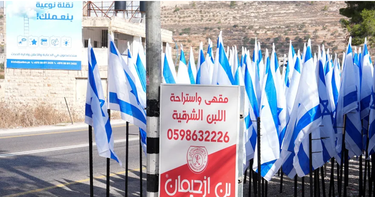 مستوطنون يحجبون مقهى فلسطينيا في اللبن الشرقية بعشرات الأعلام الإسرائيلية